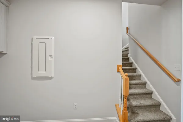 a view of staircase with wooden floor and white walls