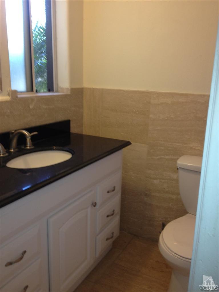 3230 Madera Place Oxnard, CA 93033 - Photo 8 of 9 a bathroom with a granite countertop toilet and a sink