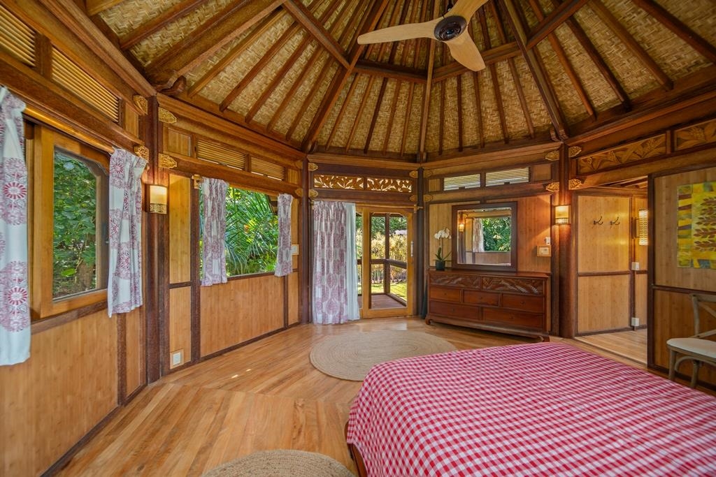 165 Waikoloa Road Hana, HI 96713 - Photo 31 of 50 a bedroom with a bed and wooden floor