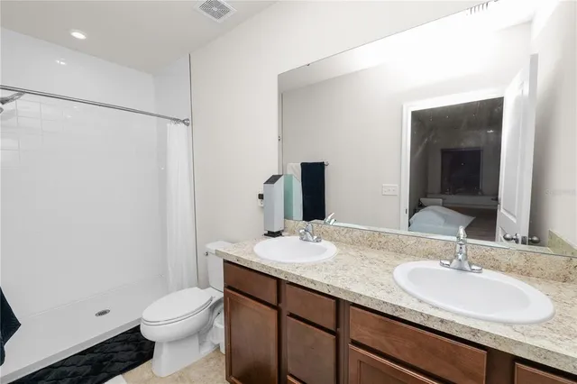 a bathroom with a granite countertop sink toilet and shower
