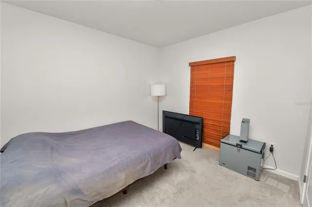 a bedroom with a bed and a lamp on desk