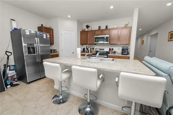 a living room with furniture a flat screen tv and kitchen view