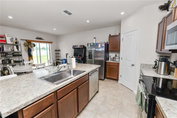 a kitchen with sink refrigerator and cabinets