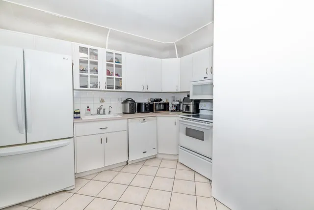 a kitchen with cabinets and chairs