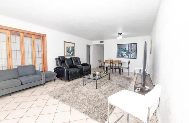 a living room with furniture and wooden floor