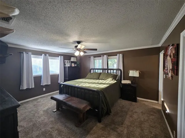 a spacious bedroom with a bed and a chandelier