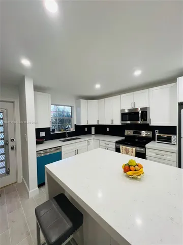 a kitchen with a sink a stove top oven a counter top space and cabinets