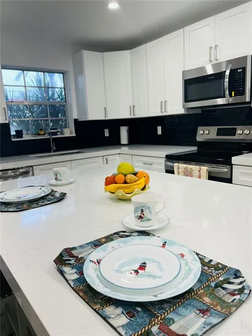 a kitchen with a sink a stove and a microwave