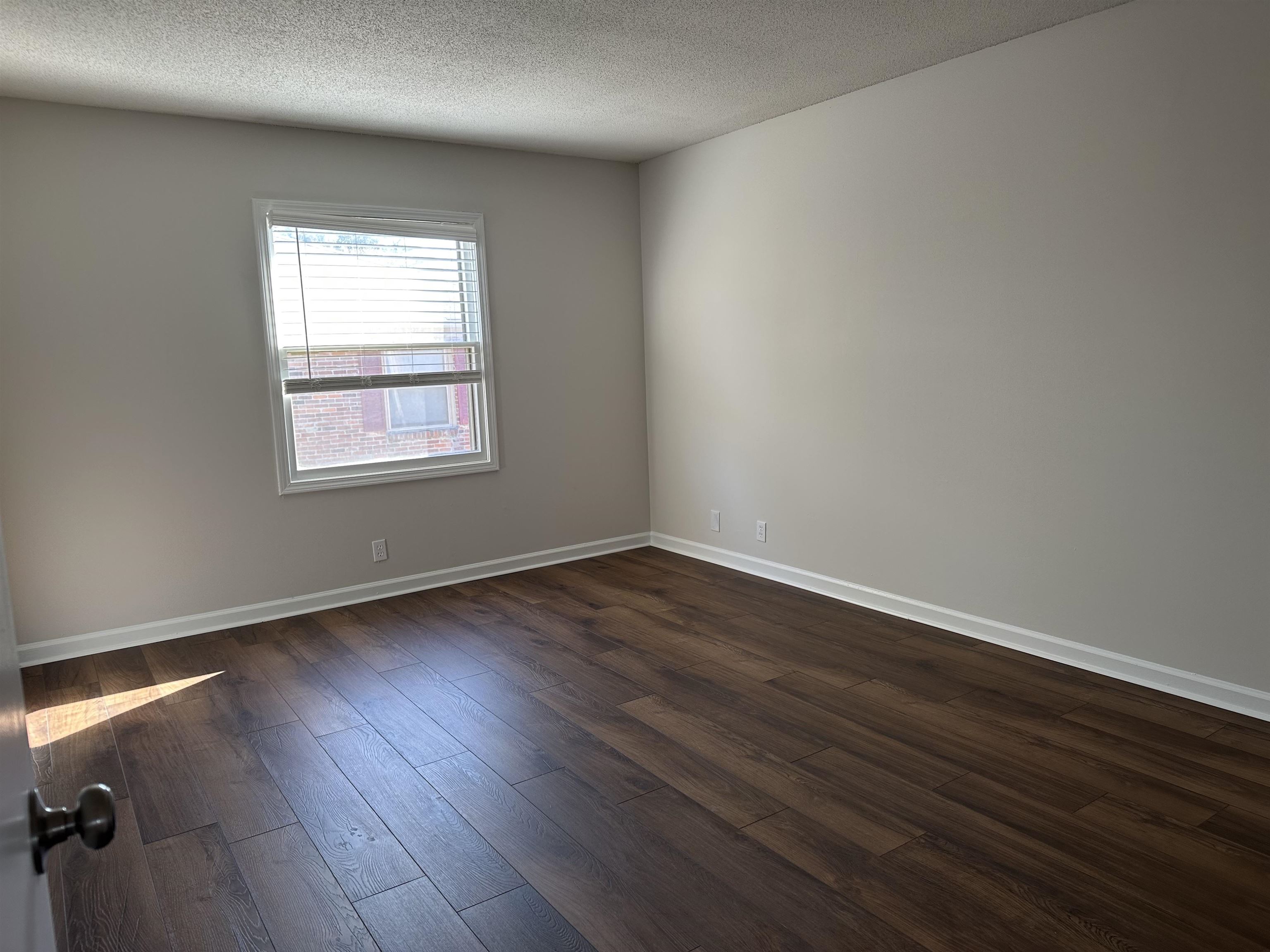 1214 Bristol Drive, Unit 1214 Memphis, TN 38119 - Photo 10 of 11 an empty room with wooden floor and windows
