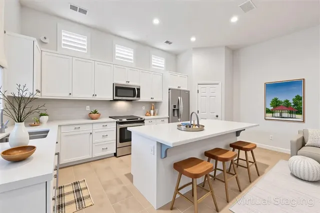 a kitchen with a sink a stove and chairs