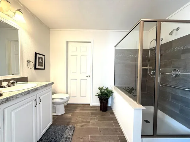 a bathroom with a granite countertop sink toilet and shower