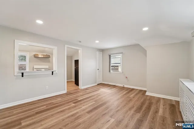 a kitchen with granite countertop cabinets stainless steel appliances and a wooden floor