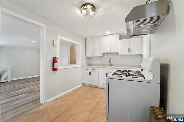 a kitchen with cabinets appliances a sink and a window