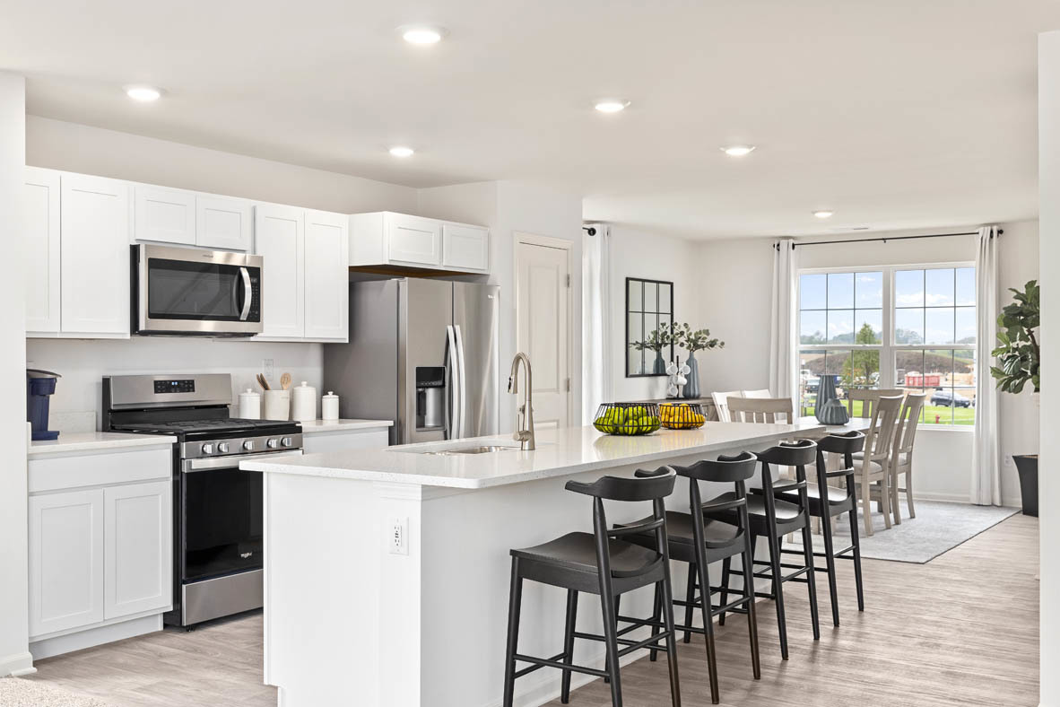 2121 Sassafras Way, Unit E Wonder Lake, IL 60097 - Photo 9 of 51 a kitchen with stainless steel appliances a stove a sink a microwave a dining table and chairs