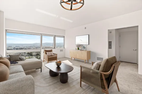 a living room with furniture and a floor to ceiling window