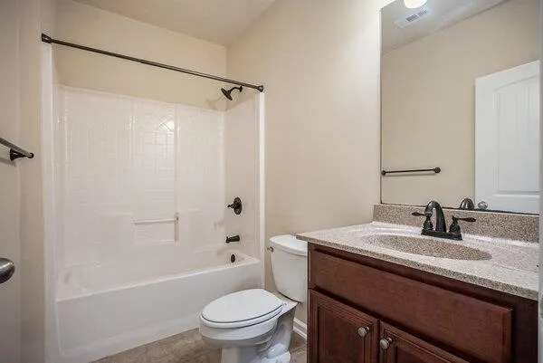 a bathroom with a sink toilet vanity and shower