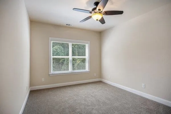 an empty room with a window and a fan