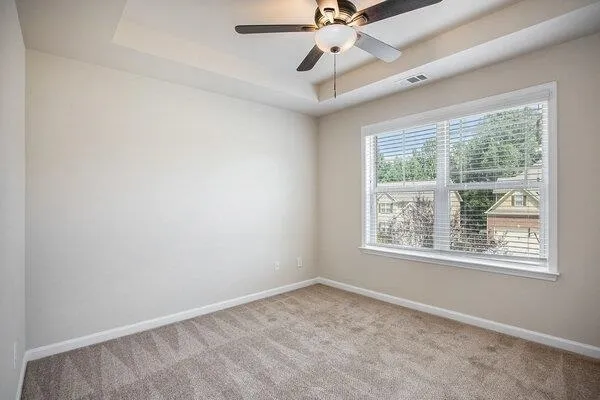 an empty room with a window and a fan