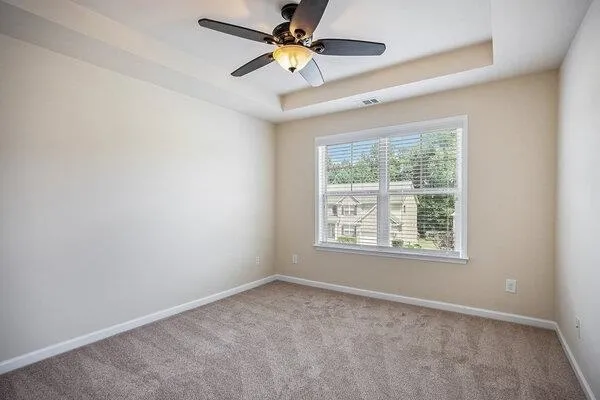 an empty room with a window and a fan