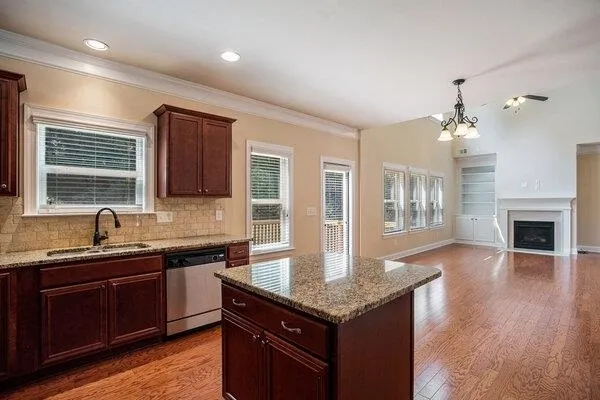 a kitchen with granite countertop a sink cabinetry and wooden floor
