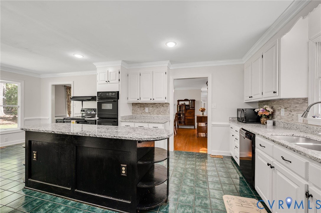 2409 Three Bridge Road Powhatan, VA 23139 - Photo 11 of 39 Kitchen featuring white cabinetry, a black island