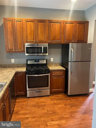 a kitchen with granite countertop a refrigerator stove and microwave