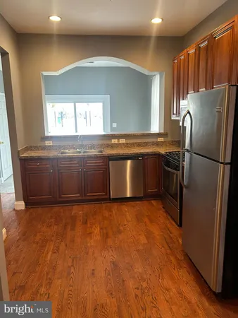 a kitchen with granite countertop a refrigerator and a sink
