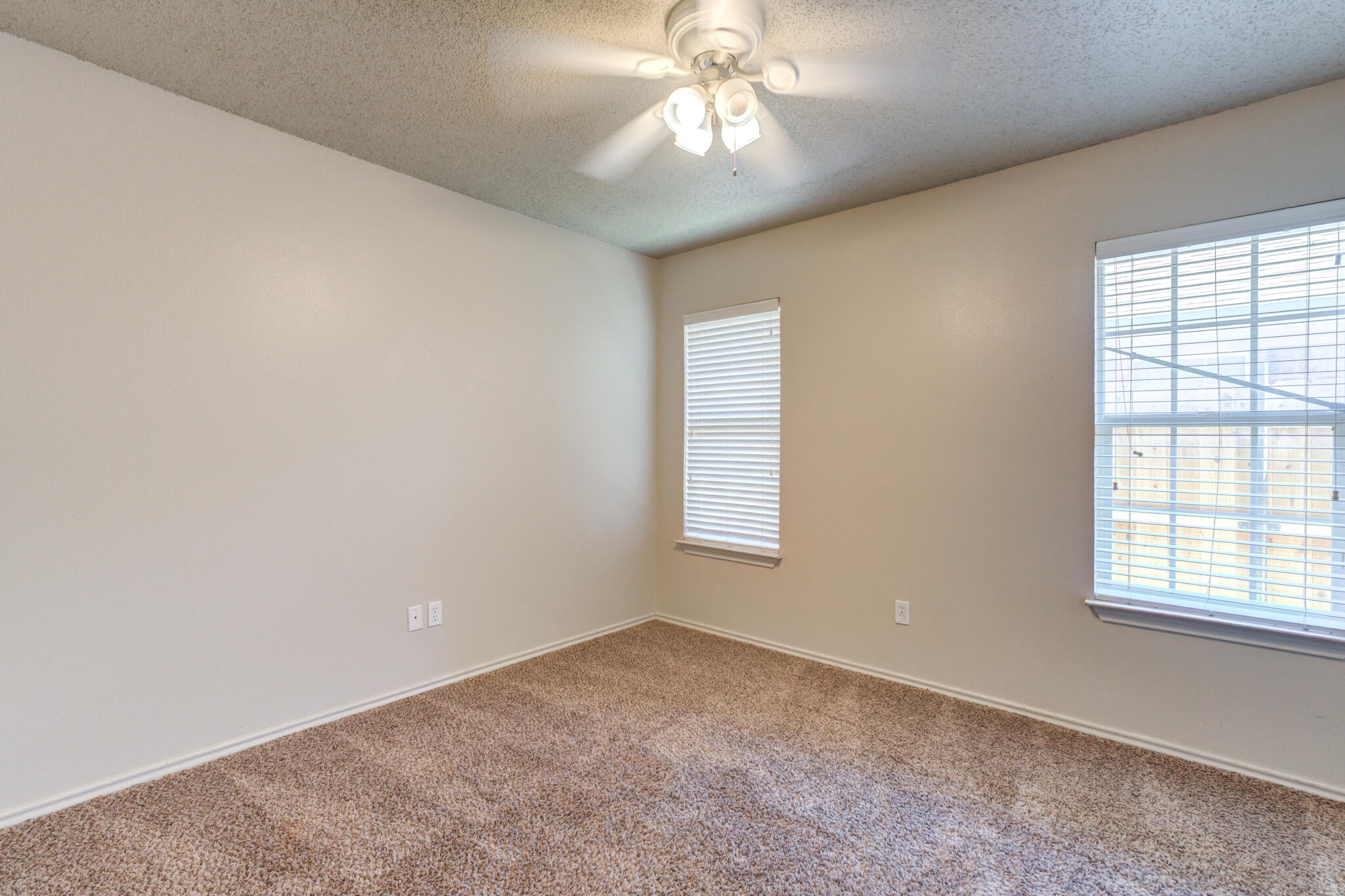 3114 109th Street Lubbock, TX 79423 - Photo 16 of 24 an empty room with a chandelier fan and windows