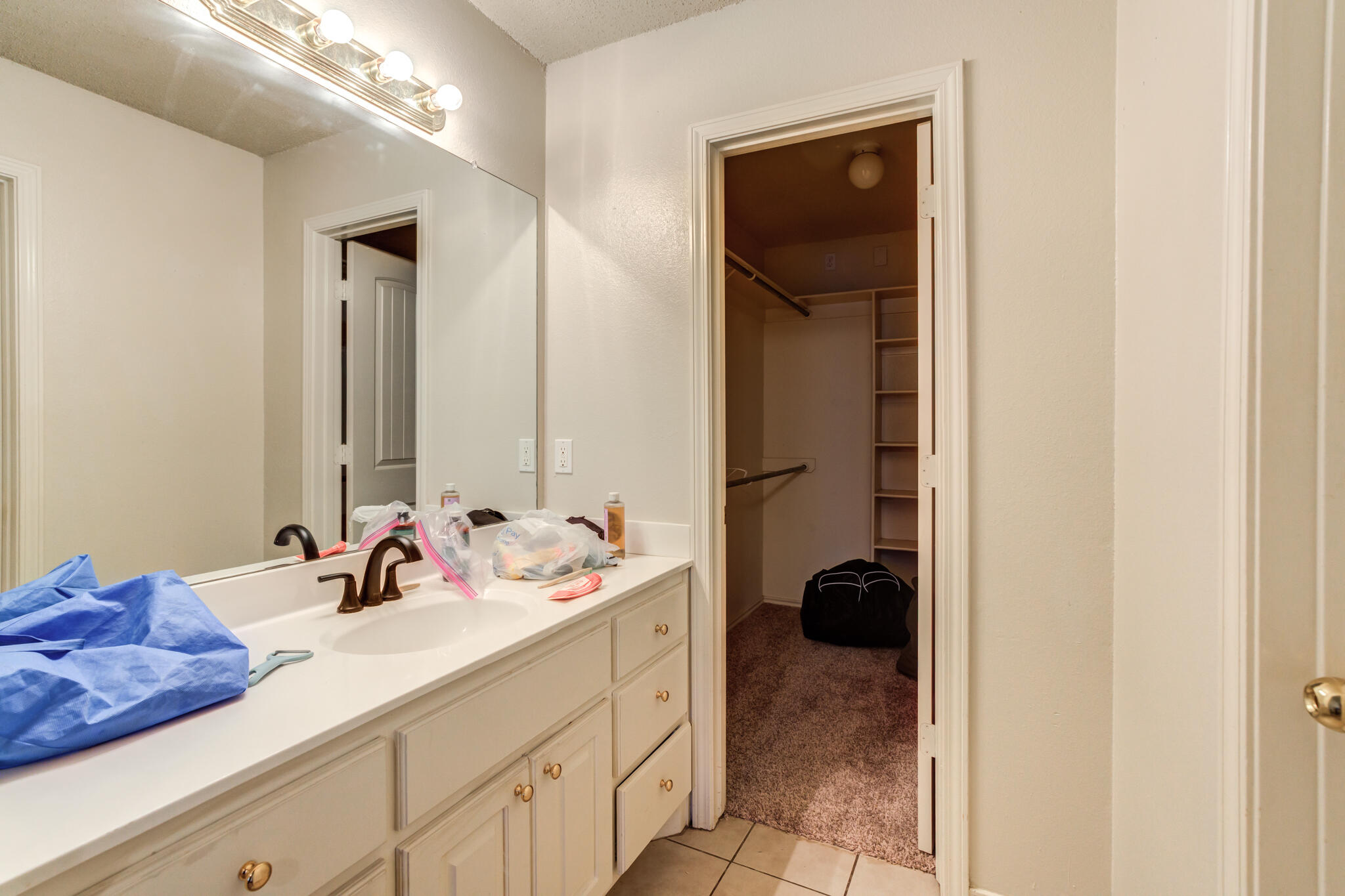 3114 109th Street Lubbock, TX 79423 - Photo 23 of 24 a bathroom with a sink and a mirror