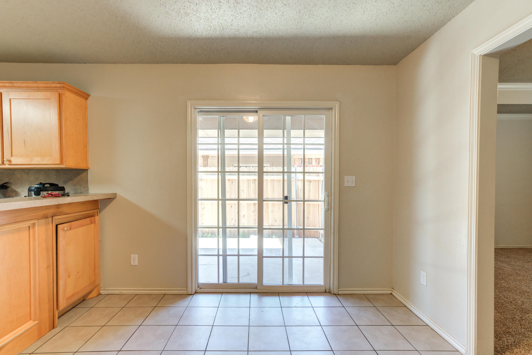 3114 109th Street Lubbock, TX 79423 - Photo 10 of 24 a view of an empty room with window and a kitchen