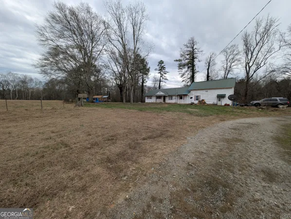a view of a field with trees in the background