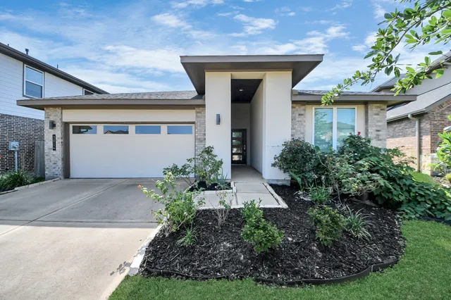 a front view of a house with a garden