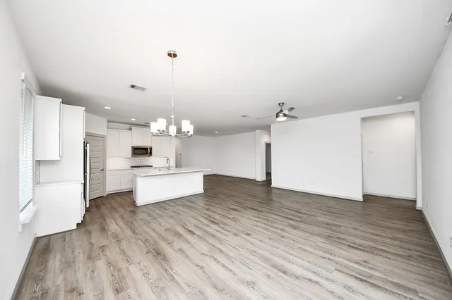 a large kitchen with kitchen island a refrigerator sink and white cabinets