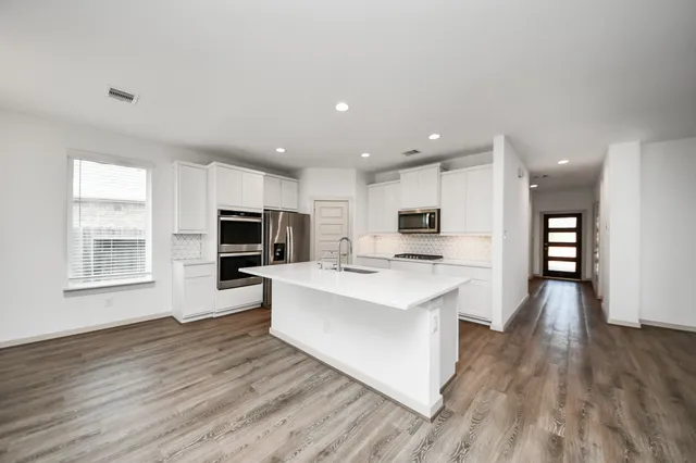 a view of kitchen with cabinets microwave and stove
