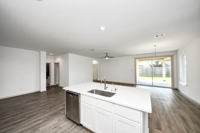 a room with a sink window and wooden floor