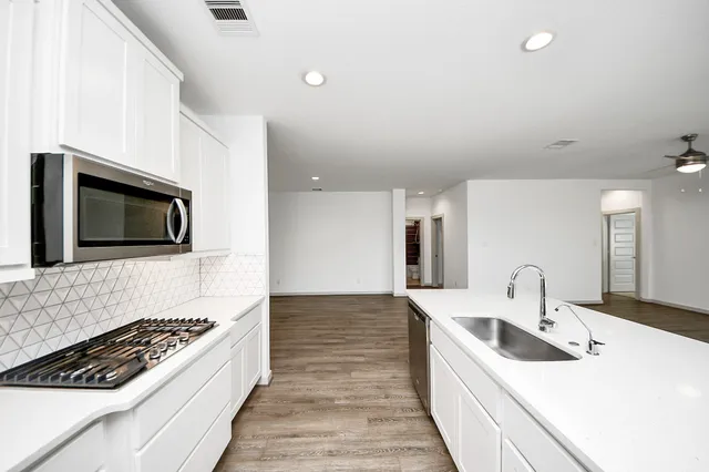 a kitchen with a sink stove and microwave