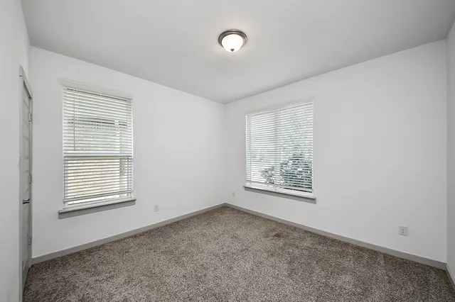 a view of an empty room with a window and a ceiling fan