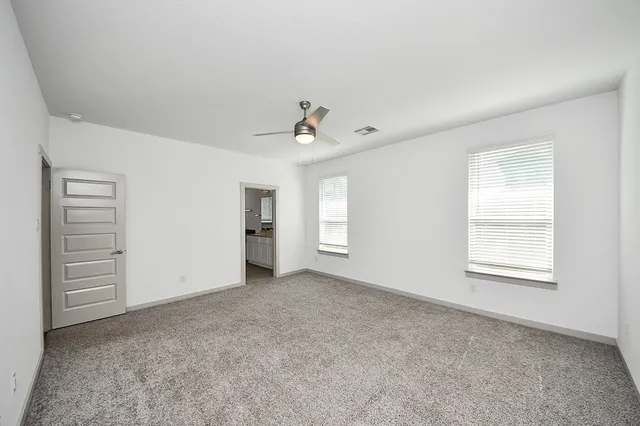 an empty room with closet and ceiling fan