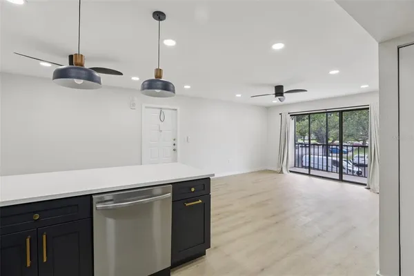 a kitchen with stainless steel appliances granite countertop a sink a refrigerator and a window