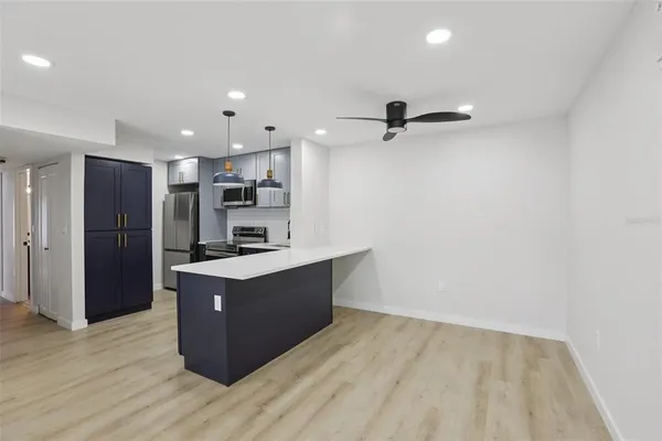 a view of kitchen with sink and refrigerator