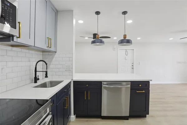 a kitchen with stainless steel appliances a sink and a wooden floor
