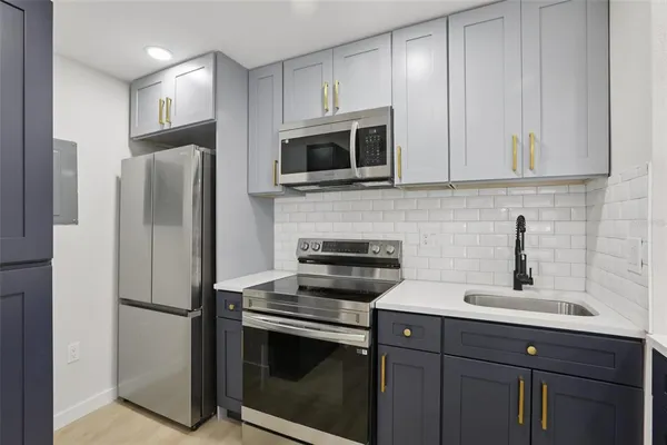 a kitchen with stainless steel appliances a stove microwave and sink