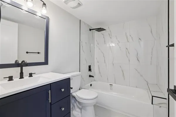 a bathroom with a double vanity sink toilet and shower