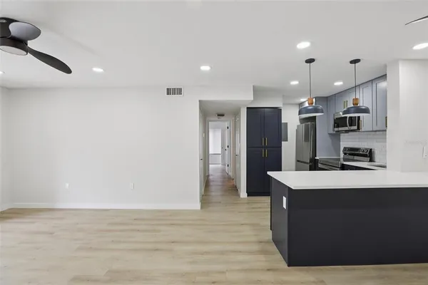 a large kitchen with stainless steel appliances a large counter top a refrigerator and a stove