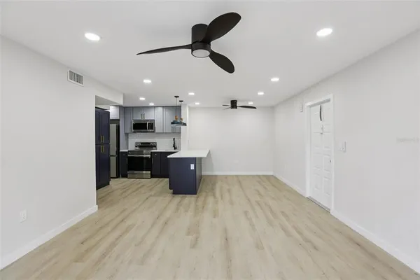 a kitchen with stainless steel appliances granite countertop a refrigerator a sink dishwasher a stove and a refrigerator with wooden floor