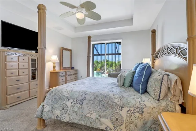 a bedroom with a bed and a flat tv screen on dresser