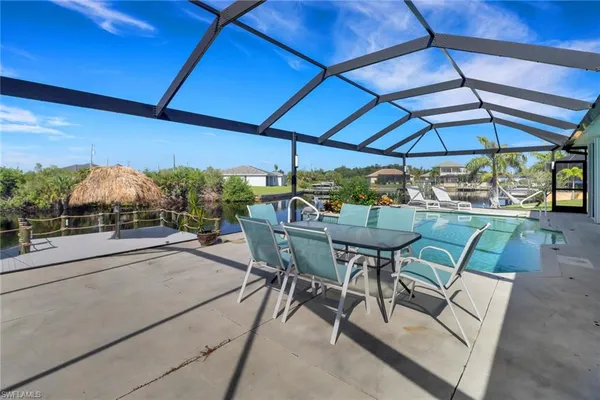 a view of patio with table and chairs under an umbrella