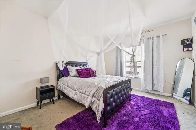 a bedroom with a bed a couch and a large window