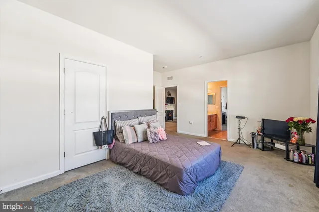 a spacious bedroom with a bed a table and chair