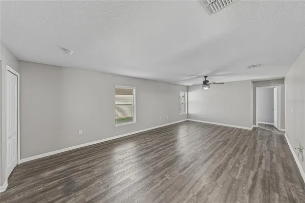 a view of a livingroom with wooden floor and a ceiling fan